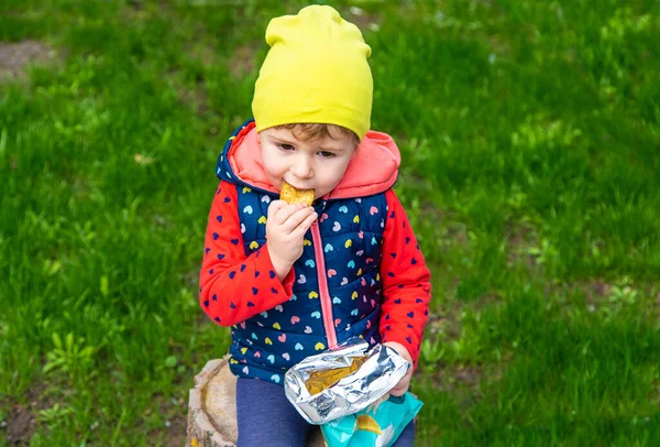 子供は公園でチップを食べる 選択的フォーカス — ストック写真