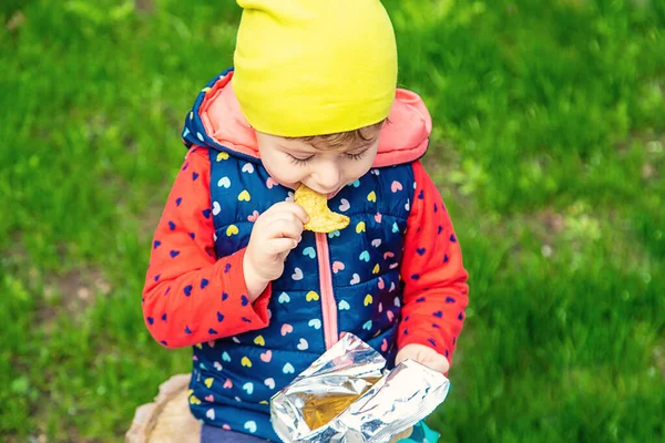 Ребенок Ест Чипсы Парке Выборочный Фокус Природа — стоковое фото