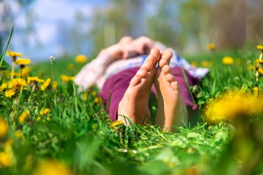 Bahar karahindiba bahçesindeki çimlerin üzerinde çocuk ayakları. Seçici odaklanma. Doğa.