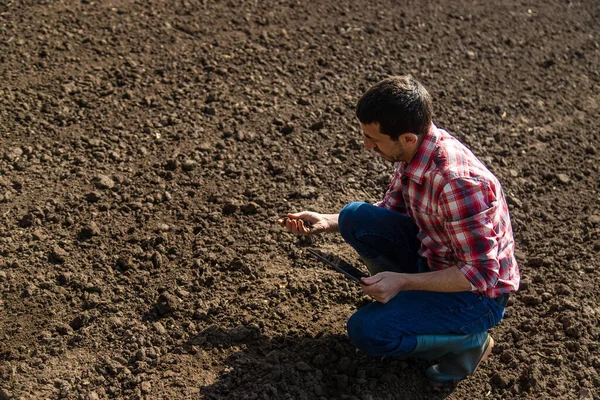 stock image Male farmer in the field checks the soil. Selective focus. Nature.