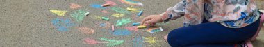 Children draw with chalk on the pavement. Selective focus. Kid.