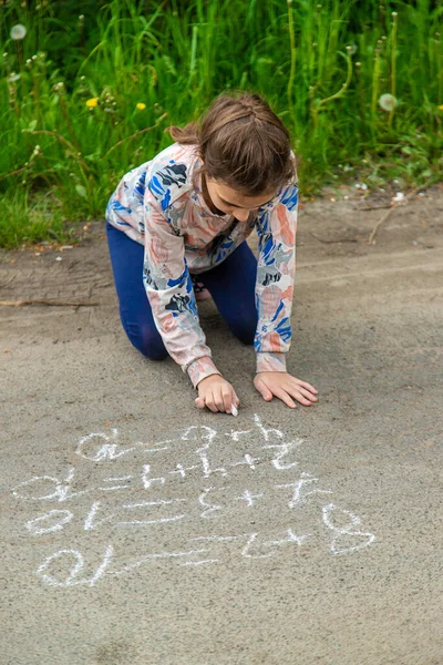 子供たちはチョークで舗装の方程式を描く 選択的フォーカス キッド — ストック写真
