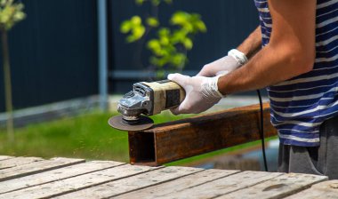 Bir adam metal bir direği işliyor. Seçici odaklanma. Doğa.