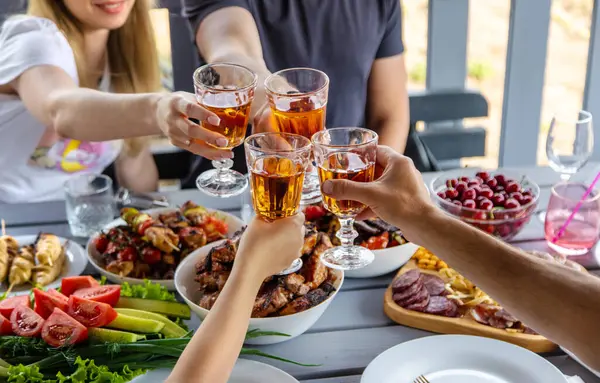 야채와 고기는 와인과 사람들과 테이블에 구워집니다 선택적인 식료품 — 스톡 사진