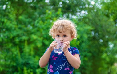 Bir çocuk bardaktan su içer. Seçici odaklanma. Yiyecek..