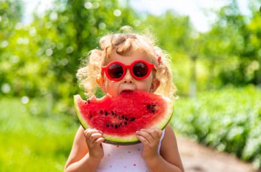 Bir çocuk parkta karpuz yiyor. Seçici odaklanma. Yiyecek..