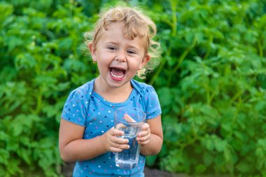 Bir çocuk bardaktan su içer. Seçici odaklanma. Çocuk.