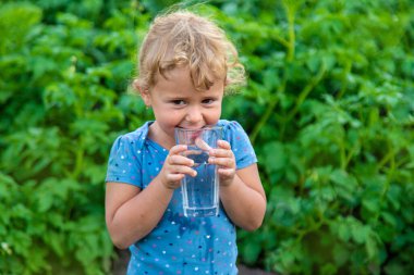 Bir çocuk bardaktan su içer. Seçici odaklanma. Çocuk.