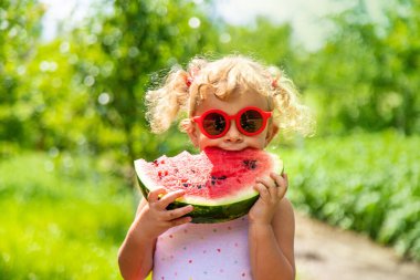 Bir çocuk parkta karpuz yiyor. Seçici odaklanma. Yiyecek..