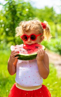 Bir çocuk parkta karpuz yiyor. Seçici odaklanma. Yiyecek..