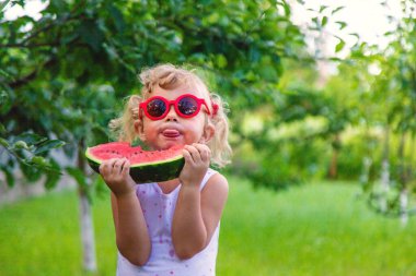 Bir çocuk parkta karpuz yiyor. Seçici odaklanma. Yiyecek..