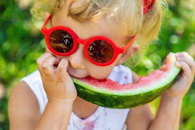 Bir çocuk parkta karpuz yiyor. Seçici odaklanma. Yiyecek..