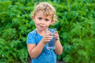 Bir çocuk bardaktan su içer. Seçici odaklanma. Çocuk.