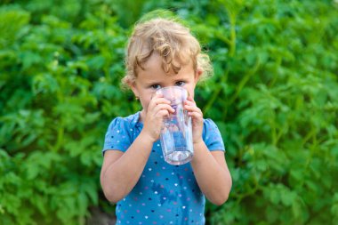 Bir çocuk bardaktan su içer. Seçici odaklanma. Çocuk.