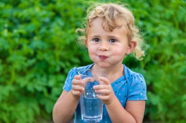 Bir çocuk bardaktan su içer. Seçici odaklanma. Çocuk.