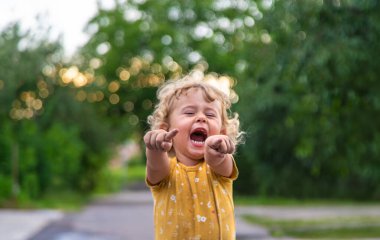 Bir çocuk sokakta bir portreyi işaret ediyor. Seçici odaklanma. Çocuk.