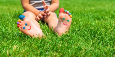 Çocuk ayakları çimlerin üzerine gülücük çiziyor. Seçici odaklanma. Çocuk.