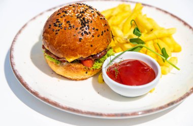 Tabakta hamburger, patates kızartması ve ketçap. Seçici odaklanma. Yiyecek..