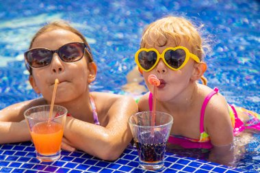 Çocuklar havuzda bir kokteyl içerler. Seçici odaklanma. Çocuklar.