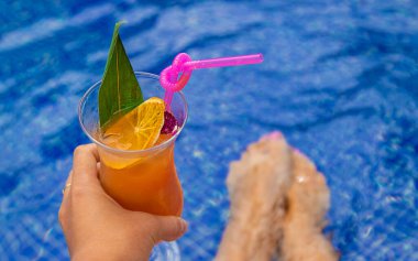 Havuzda bir kadın kokteyl içiyor. Seçici odaklanma. Seyahat.
