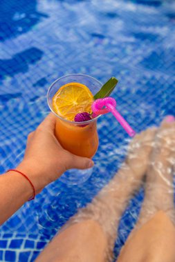 Havuzda bir kadın kokteyl içiyor. Seçici odaklanma. Seyahat.