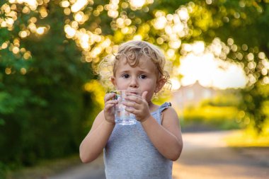 Bir çocuk bardaktan su içer. Seçici odaklanma. Çocuk.