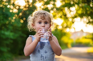 Bir çocuk bardaktan su içer. Seçici odaklanma. Çocuk.