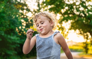 Çocuk elinde bir çiçek tutuyor. Seçici odaklanma. Çocuk.