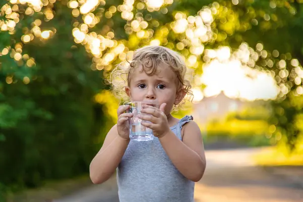 Bir çocuk bardaktan su içer. Seçici odaklanma. Çocuk.