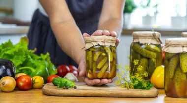 Mutfaktaki kavanozlarda sebze konservesi konservesi yapan kadın. Seçici odaklanma. Yiyecek..