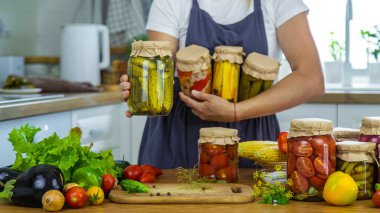 Mutfaktaki kavanozlarda sebze konservesi konservesi yapan kadın. Seçici odaklanma. Yiyecek..