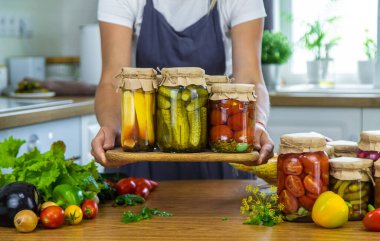 Mutfaktaki kavanozlarda sebze konservesi konservesi yapan kadın. Seçici odaklanma. Yiyecek..