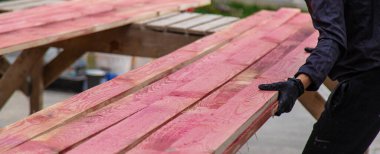 Bir adam tahtaya kırmızı bir antiseptik veriyor. Seçici odaklanma. Doğa.