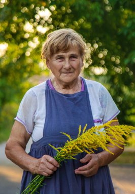 Yaşlı bir kadının yabani otlara alerjisi vardır. Seçici odaklanma. Doğa.