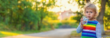 Bir çocuk bardaktan su içer. Seçici odaklanma. Çocuk.