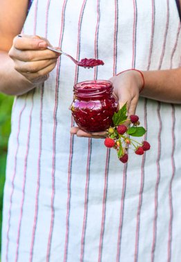 Bir kadının ellerinde ahududu reçeli. Seçici odaklanma. Yiyecek..