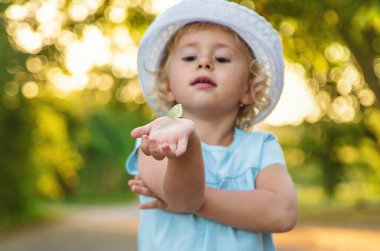 Bir çocuk doğada bir kelebek yakalar. Seçici odaklanma. Doğa.
