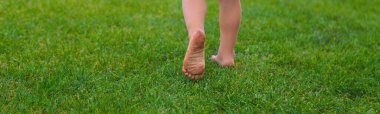 Çimlerin üzerinde çocuk ayakları. Seçici odaklanma. Çocuk.
