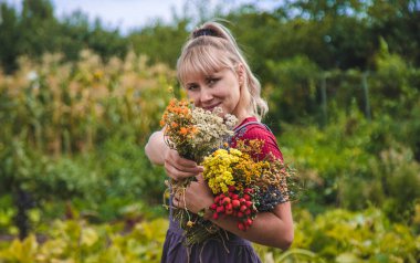 Bir kadın elinde şifalı bitkiler tutar. Seçici odaklanma. Doğa.