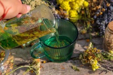 Bir kadın bitki çayı yapar. Seçici odaklanma. Doğa.