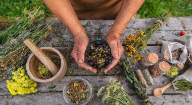 Yaşlı bir kadın bitki çayı yapar. Seçici odaklanma. İç..