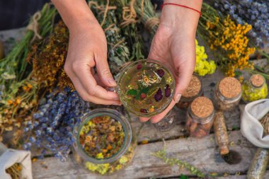 Kadın bitki çayı yapıyor. Seçici odaklanma. Doğa.