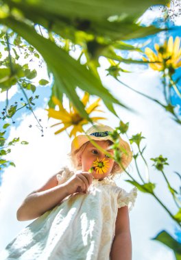 Yazın çiçeklerle parktaki çocuklar. Seçici odaklanma. Doğa.
