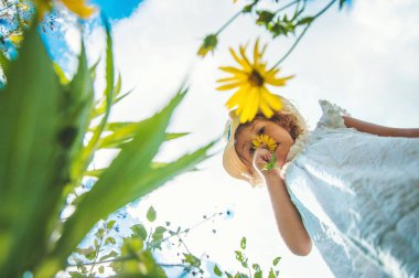 Yazın çiçeklerle parktaki çocuklar. Seçici odaklanma. Doğa.