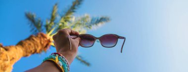 Palmiye ağacına karşı güneş gözlüğü. Seçici odaklanma. seyahat.