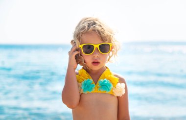 Deniz kabuğunu dinleyen bir çocuk. Seçici odaklanma. Doğa.