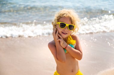 Deniz kabuğunu dinleyen bir çocuk. Seçici odaklanma. Doğa.