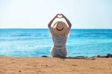 Deniz kıyısında şapkalı bir kadın. Seçici odaklanma. Çocuk.