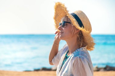 Deniz kıyısında şapkalı bir kadın. Seçici odaklanma. Çocuk.