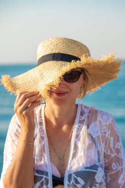 Deniz kıyısında şapkalı bir kadın. Seçici odaklanma. Çocuk.